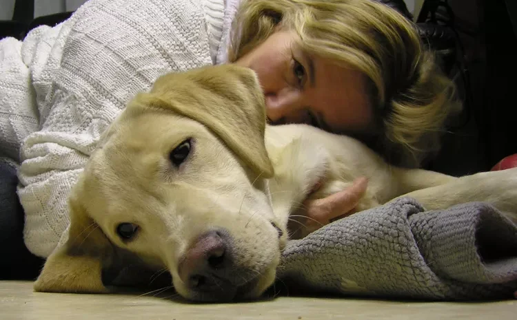 A woman cuddling with a dog